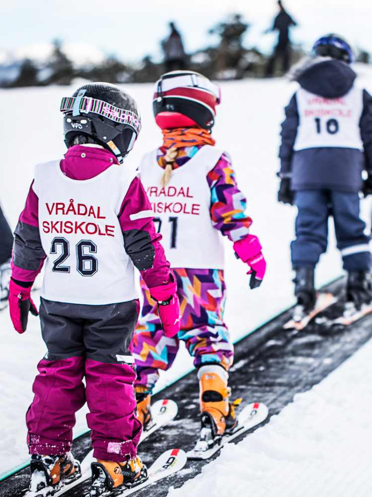 Kids in Vrådal Ski School gear, gathered for ski lessons, capturing the delightful moments of winter learning and fun.