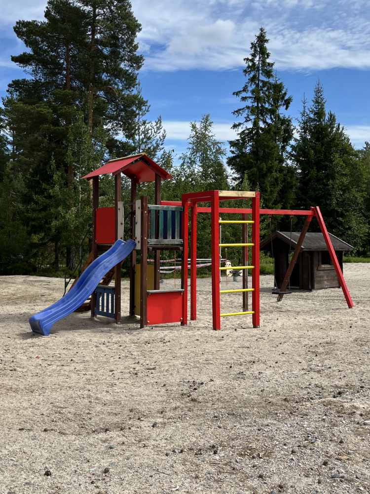 Red climbing frame with swing and slide in the Vrådal Panorama valley.
